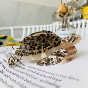 Artistic sea turtle hair claw clip with tortoise shell pattern on vintage newspaper