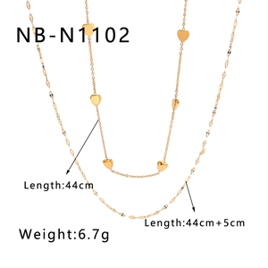 Detailed view of golden double-layer necklaces with heart pendant and leaf texture chain