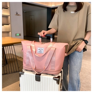Pink large travel bag on luggage handle showing expandable bottom and nylon texture