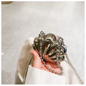 Detail of a silver lip-shaped metal evening bag with glossy mirror finish and chain strap