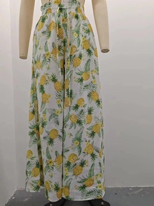 Detail of high-waist loose wide-leg trousers with yellow pineapple print on white fabric