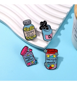 Detailed close-up of four enamel jar brooches with colorful candy star designs