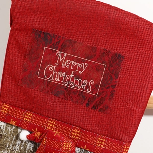 Red burlap Christmas stocking with Merry Christmas text and gold snowflake ribbon detail