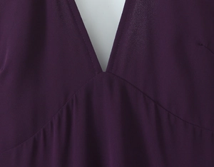 Close-up of deep purple chiffon dress featuring a sexy deep V-neckline and fine stitching