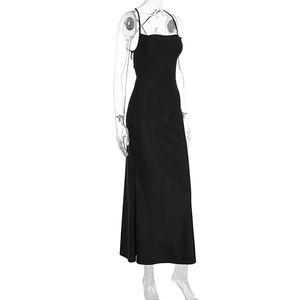 Detail of minimalist black satin maxi dress featuring thin straps and sleek straight cut