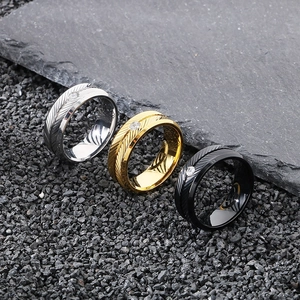 Macro shot of stainless steel feather rings with inset diamonds in silver gold and black