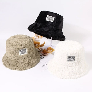 Détail de chapeaux d'hiver en peluche noirs, kakis et blancs avec texture douce et poilue