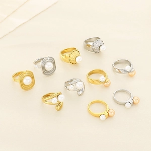 Macro detail of gold and silver textured rings featuring elegant shell pearl embellishments