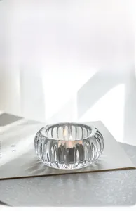 Gros plan du bougeoir en verre nervuré avec lumière douce et texture verticale