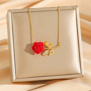 Collier élégant avec pendentif rose rouge, chaîne dorée et feuilles de zircone sur soie