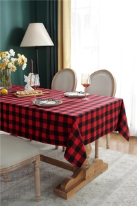 Close-up of red and black buffalo plaid tablecloth texture on a wooden dining table
