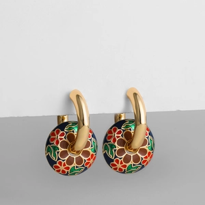 Detailansicht der vergoldeten Creolen mit blauen Emaille-Blumenanhängern im Vintage-Stil