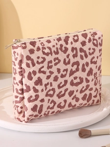 Detail of pink quilted leopard print makeup bag with zipper closure on white tray