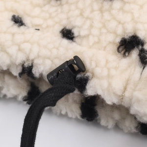Détail du tissu polaire doux à motif vache avec cordon de serrage et arrêt noir