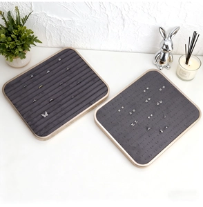 Detailed view of champagne gold jewelry display trays with grey velvet for rings and studs