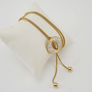 Gold-tone tassel sweater necklace with pavé crystal circle pendant on jewelry pillow