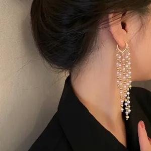 Elegant long tassel pearl earrings with heart hook shown on a model side profile view