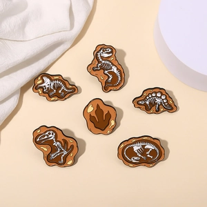 Detailed close-up of six unique dinosaur fossil skeleton enamel pins with earthy tones