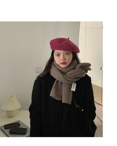Detailed close-up of thick ribbed knit scarf in brown with matching rose pink beret hat