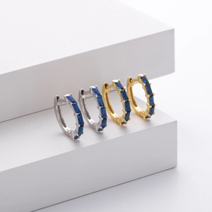 Detail showing silver and gold 925 sterling silver hoop earrings with blue square zircons