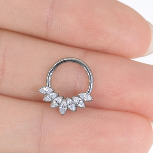 Macro shot of silver titanium ring with marquise-cut zircons worn on a finger