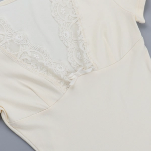 Détail d'un haut en coton côtelé blanc cassé avec dentelle et nœud au col en V élégant