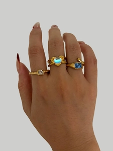 Detailed view of irregular gold rings with hammer texture and colorful gemstone insets