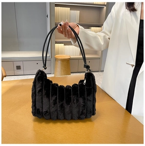 Dettaglio borsa nera in peluche con trama a strisce e raffinati accessori in metallo