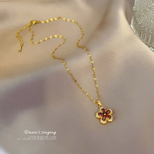 Detail of garnet five-leaf flower necklace with crystals on silk background