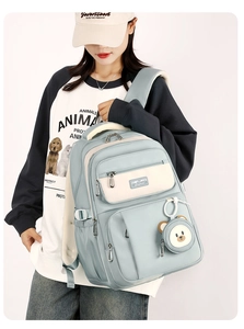 Teenager girl in mint blue large capacity backpack with cute bear pendant detail