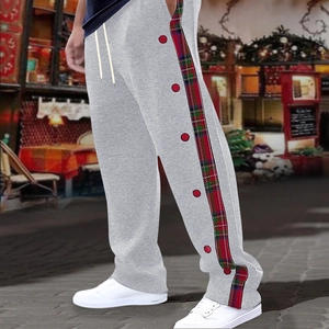 Detail of grey joggers featuring red plaid side stripes and functional snap buttons