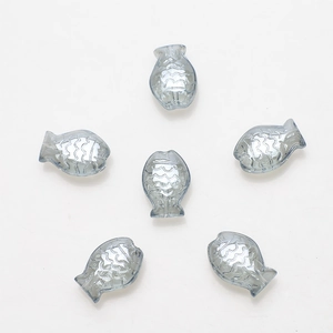 Macro shot of 10x14mm fish-shaped glass beads with embossed scale texture and center holes