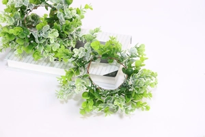 Detail of frosted eucalyptus candle rings on a book, festive table decor accessories