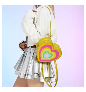 Detail of yellow heart-shaped crossbody bag with rainbow pattern in a Y2K fashion style