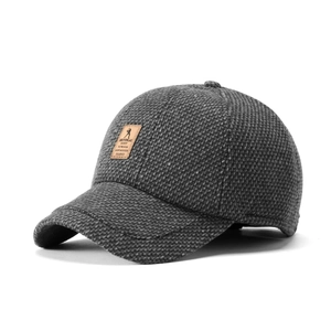 Close-up of winter knit baseball cap fabric texture and leather golf emblem detail