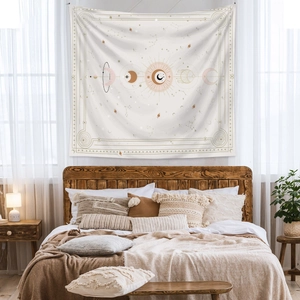 Detail of celestial tapestry featuring moon phases and stars above a retro wooden bed