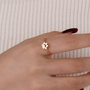 Bague patte de chat en or rose portée par un mannequin sur un fond en maille douce