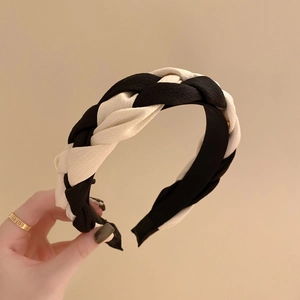 Detail shot of a black and white braided headband with thick fabric texture and contrast