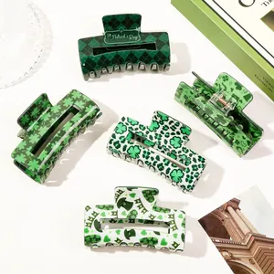 Close-up detail of green St. Patrick's Day hair claw clips with clover patterns