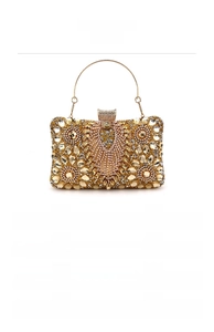 Detail of a gold evening bag featuring intricate rhinestone patterns and metal handles
