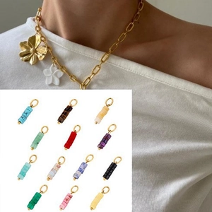 Golden chain necklace with colorful cylindrical stone pendants and flower charm detail