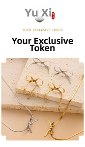 Artistic layout of gold and silver bow stud earrings and snake chain necklaces on beige stone
