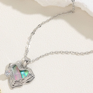 Macro detail of a silver heart pendant with colorful shell inlay and sparkling zircon
