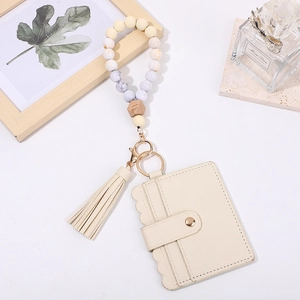Detail of beige PU card holder and gradient silicone beaded keychain with a tassel