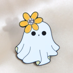 Ghost enamel pin with yellow flower and rhinestone on white silk background