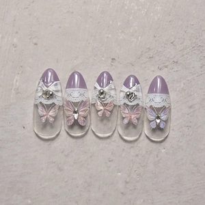 Detail of purple butterfly nail stickers with lace patterns, rhinestones, and pearls