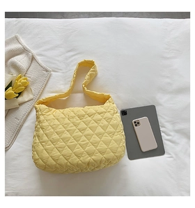 Detail of yellow quilted cloud bag with diamond lattice pattern and soft fabric texture