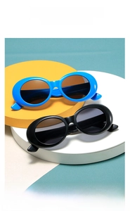 Nahaufnahme der Retro-Oval-Kindersonnenbrille in Blau und Schwarz auf einem Studio-Display