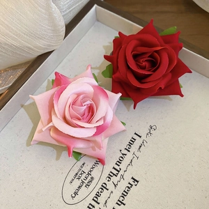 Elegant fabric rose flower hair clips in deep red and pink white gradient on a tray