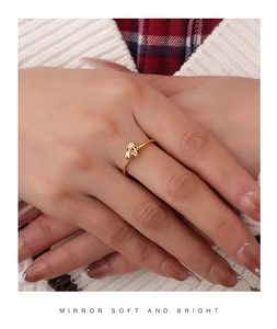Detailed view of an 18K gold palm tree ring styled with a warm autumn outfit